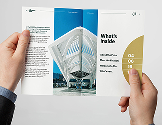 A mockup of someone holding the inside spread to the Earthshot Prize guide, with a large photo of the Museum of Tomorrow.