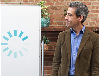 From the video: Daniel Biss looks at his whiteboard with a broken loading animation on it